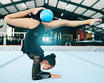 Balance, gymnastics and woman stretching with a ball for a competition, practice or training. Fitness, sports and female athlete gymnast doing a flexibility, agility and endurance exercise in a gym.