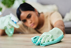 Hand, cleaning and cloth with a woman housekeeper wiping a wooden furniture surface using disinfectant. Gloves, wipe and hygiene with a female cleaner in a home for housekeeping or sanitizing