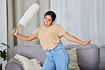 Music, dance and cleaning with a woman housekeeper in a home alone for hygiene while having fun. Radio, dancing and housekeeping with a female cleaner streaming or listening to audio in a living room