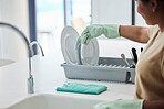 Woman, hand and dishes in kitchen by sink for washing, packing or hygiene in house with gloves. Cleaner lady, hands or home for dry plate, stop bacteria or cleaning service for health in apartment
