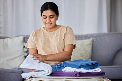 Buy stock photo House, cleaning and woman fold laundry on a sofa, happy and relax alone in her home. Towels, housework and indian female relaxing while sorting fabric, linen and fresh cloth on the weekend or day off