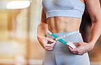 Stomach, tape measure and woman at gym for weight loss, diet or exercise on blurred background. Fitness, measuring and girl on flat belly from training, workout or healthy lifestyle results on mockup