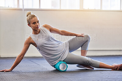Buy stock photo Fitness, physio and pilates, woman with roller on floor for leg tension and support in yoga workout at gym. Health, sports and massaging for physiotherapy massage, girl on ground foam rolling muscle.