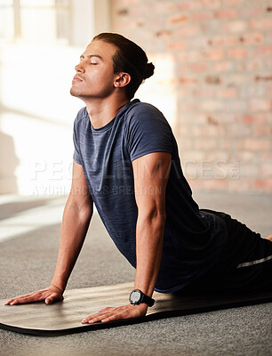 Buy stock photo Calm, yoga and man stretching in a gym with fitness, exercise and workout for wellness. Breathing work, pilates and body stretch of a athlete on the ground of a health and training center to relax
