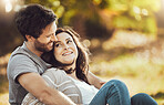 Love, couple and relax at park, laughing at funny joke or comic comedy and having fun time together outdoors. Valentines day, romance hug and care of happy man and woman sitting on romantic date.