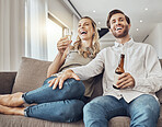 Couple relax with alcohol drink, watching tv and funny with quality time together in living room with love and commitment. Happy people, comedy entertainment and laughter with happiness at home
