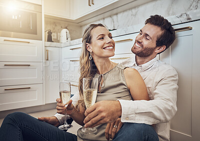 Buy stock photo Celebrate, love and couple with champagne in kitchen for honeymoon, anniversary and valentines day. Happy, relax and young man and woman drinking alcohol on the floor with conversation in marriage
