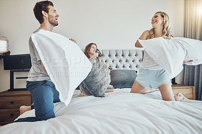 Buy stock photo Family in pillow fight, happy and fun together at home, parents and child in bedroom, playful and bonding. 
Man, woman and girl play game, funny and crazy with energy and laughter with love