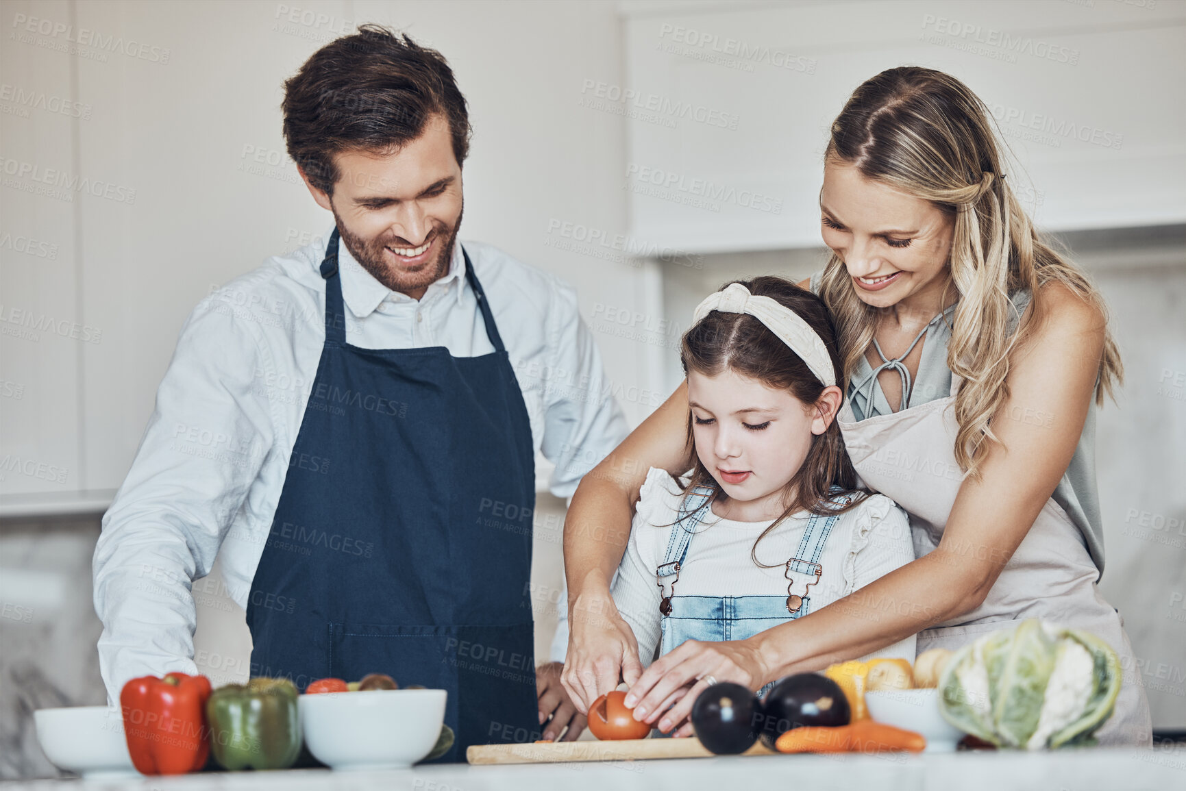 Buy stock photo Learning, parents or girl cooking vegetables as a happy family in a house kitchen with organic food for dinner. Development, father or mother teaching, helping or cutting tomato with a healthy child