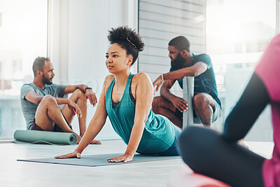 Yoga, fitness class and people exercise together for health, peace and wellness. Black woman and men group in health studio for holistic workout, cobra and body balance with zen energy or mindfulness