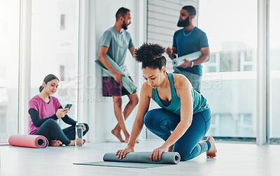 Buy stock photo Yoga, fitness and a black woman rolling her mat on the floor of a studio for exercise or wellness. Gym, workout and health with a female yogi in the gym for pilates training or spiritual wellbeing