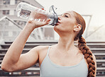 Fitness, hydration and a sports woman drinking water outdoor in the city during cardio or endurance exercise. Runner, workout and hydrated with a female athlete training in an urban town for health