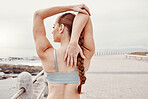 Woman stretching, arms and back muscle by ocean with workout for performance, fitness and flexibility in morning. Girl, outdoor warm up and start training at beach for wellness, health and exercise
