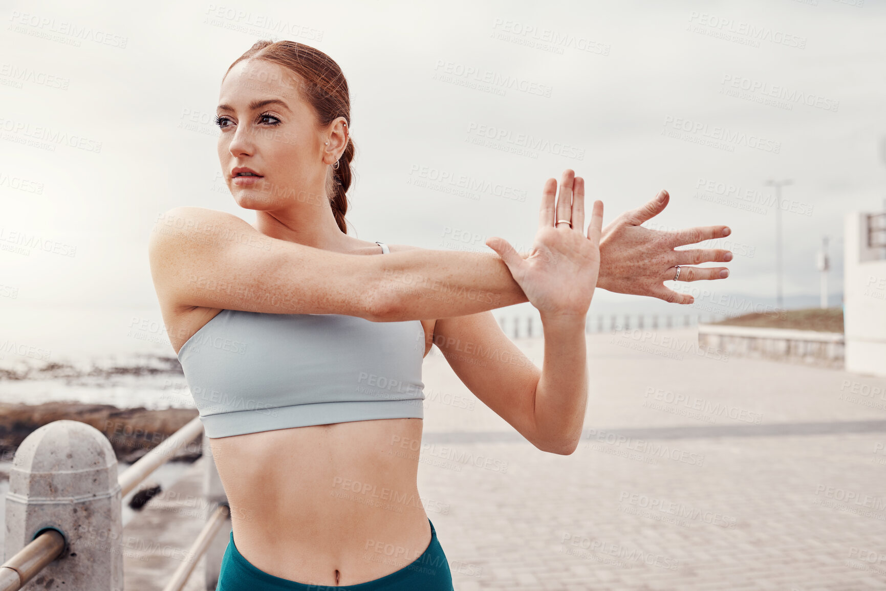 Buy stock photo Fitness, sports and woman stretching arms in city for motivation, warm up and start cardio workout by sea. Running, exercise and girl focus for healthy body, wellness and marathon training by ocean