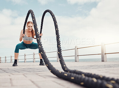 Buy stock photo Fitness, woman and battle rope at the beach for intense arm workout, training or exercise in Cape Town. Active female exercising with ropes for cardio, muscle endurance or power in the outdoors