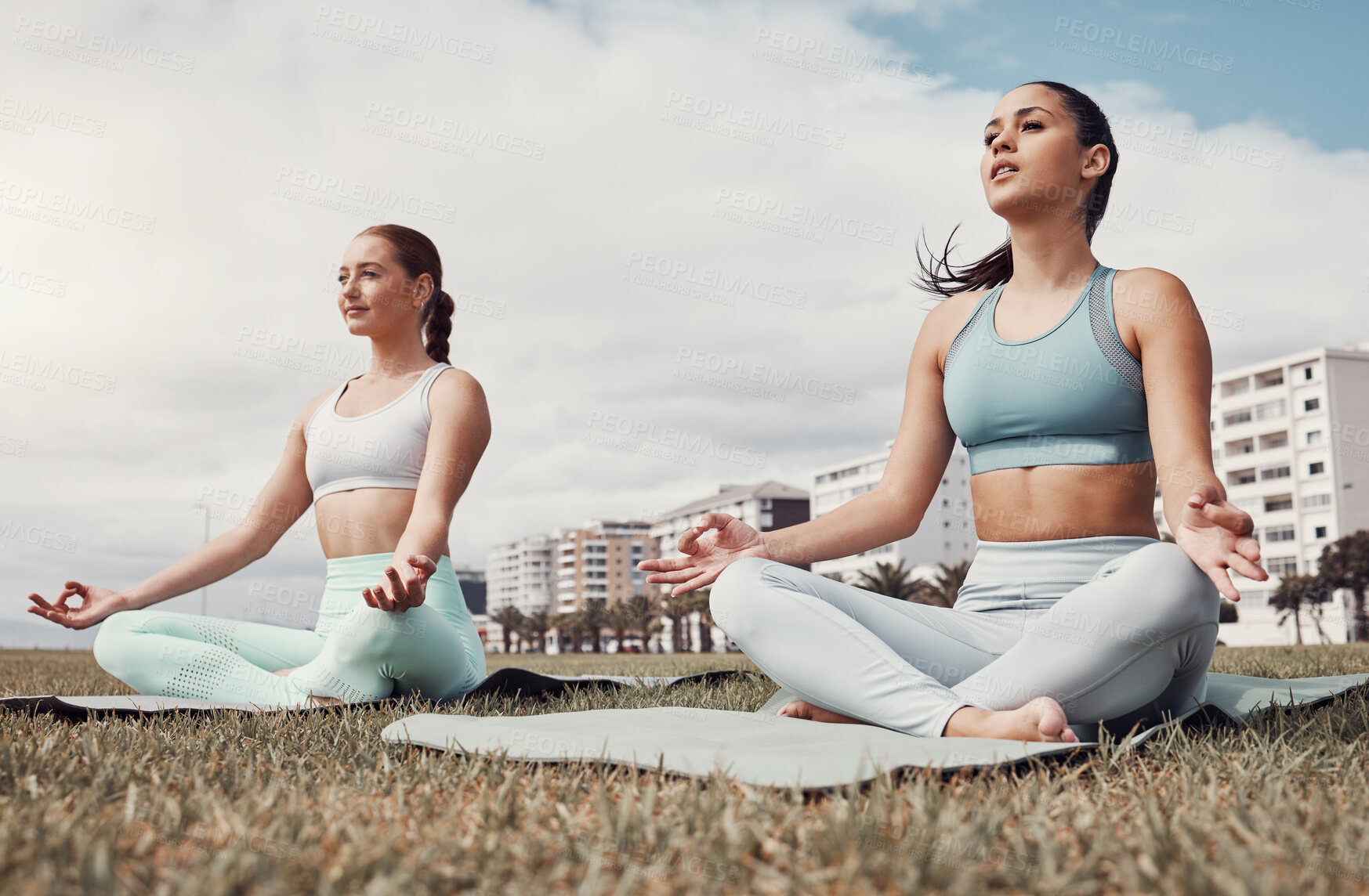 Buy stock photo Girl friends, yoga and lotus meditation on grass at urban park for peace, body wellness or focus outdoor. Gen z group, woman or mindfulness exercise on lawn by buildings, city or health to relax mind