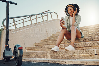Buy stock photo Black woman outdoor, scooter and phone with headphones for music, eco friendly travel and 5g for audio streaming in city. Sustainability, listen to podcast and relax on steps with transportation