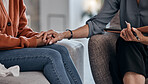 Woman, holding hands and closeup for therapy consultation, support and mental health problem on sofa. Women, helping hand and psychologist with talk, advice and care for depression in clinic office