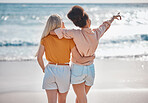 Woman, friends and hug in relax at the beach for summer vacation, travel or journey together in the outdoors. Interracial women hugging and enjoying trip, traveling or adventure by the ocean coast