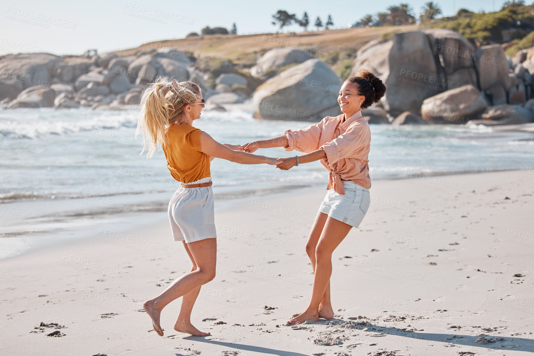 Buy stock photo Couple holding hands on beach, lesbian women have fun with travel and adventure outdoor, ocean and freedom to love. Interracial relationship, holiday in Australia and lgbtq, playful and care free