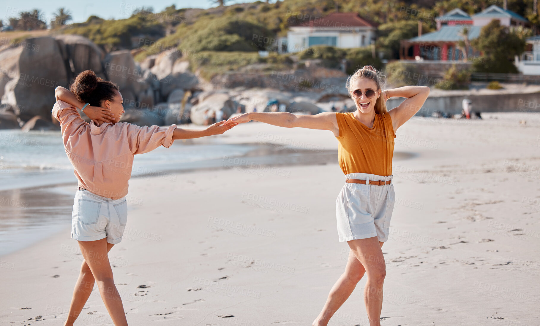 Buy stock photo Couple holding hands on beach, lesbian and fun by ocean, gay women outdoor with adventure and freedom to love. Interracial, laugh and holiday in Australia, lgbtq with travel and happy dance together
