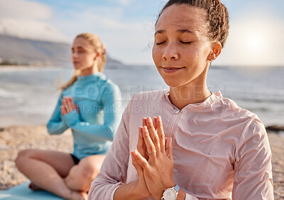 Buy stock photo Yoga, meditation and woman friends on a beach together for mental health or wellness to meditate in summer. Exercise, diversity or nature with a female yogi and friend meditating outside for fitness