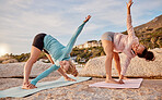 People, yoga or stretching on beach mat for relax training, workout or exercise for healthcare wellness, muscle relief or flexibility. Women, yogi or pilates friends on rock for zen fitness at sunset