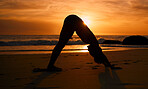 Yoga, silhouette and downward dog on sunset beach, ocean or sea in workout or relax exercise training. Yogi, woman and sand stretching at sunrise healthcare wellness, fitness pilates or strong body