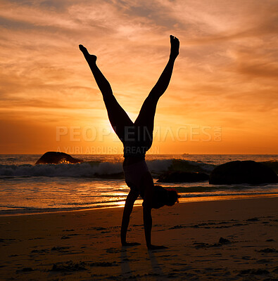 Buy stock photo Yoga woman, silhouette or handstand on sunset beach, sea or ocean in workout or relax exercise training. Yogi, pilates or sand balance pose at sunrise for healthcare wellness fitness or strong body