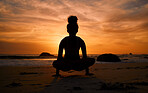 Sunset, yoga and silhouette of a woman on the beach in a lotus pose doing a meditation exercise by the sea. Peace, zen and shadow of a calm female doing a pilates workout outdoor at dusk by the ocean