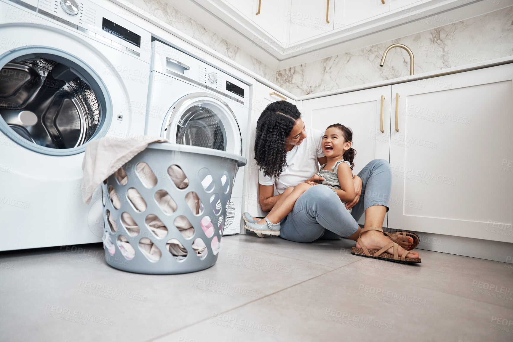 Buy stock photo Mom, girl kid and basket by washing machine on floor for cleaning, bonding and comic laugh in house. Laundry, mother and daughter with happiness, love and care in family home with happy smile for hug