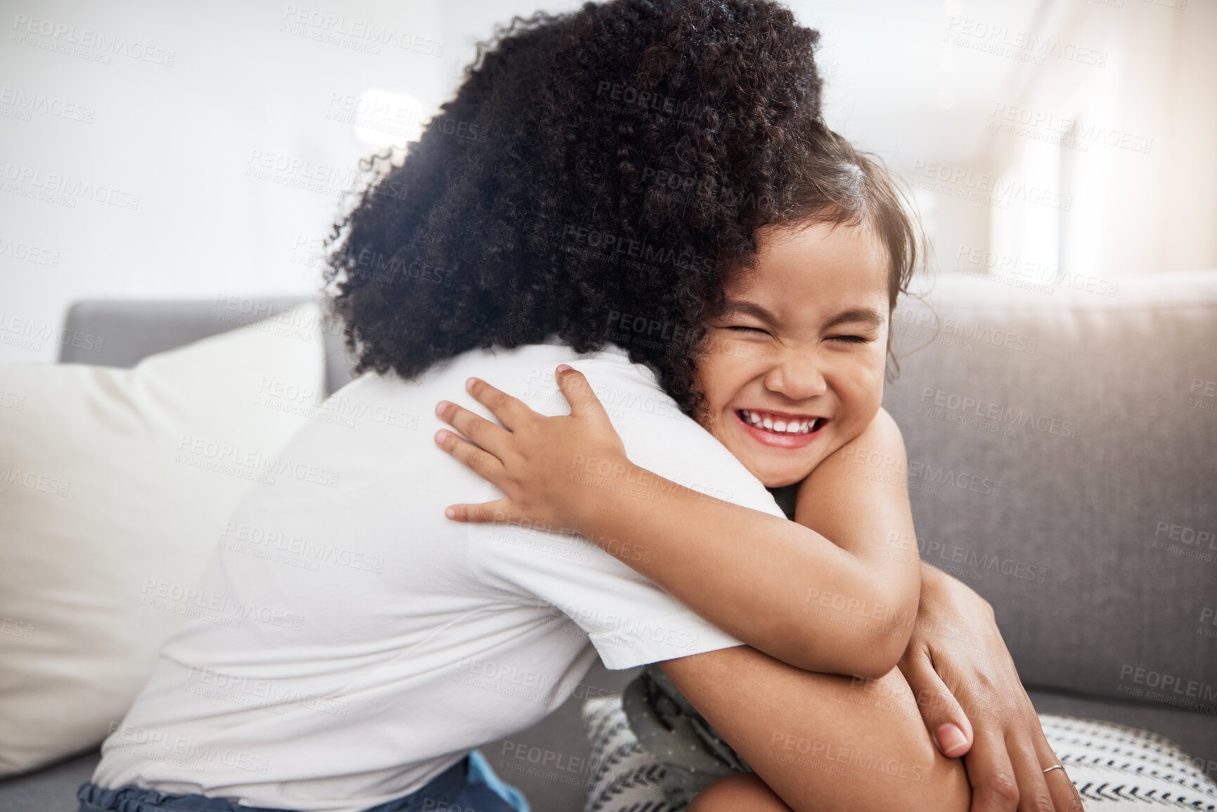 Buy stock photo Love, hug and girl with mother on a sofa, happy and smile while hugging in their home together. Family, embrace and parent with child on a couch, bond and cheerful, loving and caring in a living room