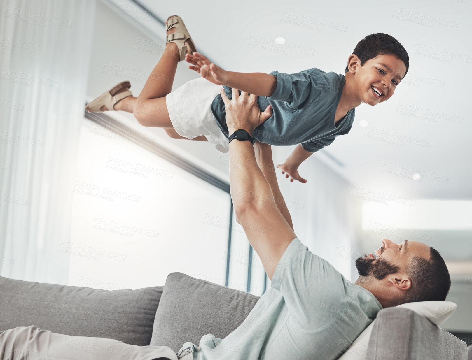 Buy stock photo Family, dad and child in air on sofa enjoy playing on holiday, vacation and weekend in living room. Love, childhood and happy face of boy in father arms for bonding, quality time and relax at home