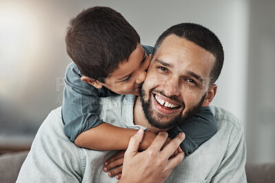 Buy stock photo Happy, love and child kissing his father while relaxing in the living room at their family home. Happiness, smile and portrait of a young man hugging and bonding with boy kid with care and in house.