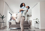 Love, man pick up woman and in living room for happiness, loving and celebration for Valentines day. Portrait, couple or male hug female in lounge, joyful or achievement with smile, relax or cheerful