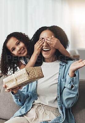 Buy stock photo Mother, girl and surprise with gift on sofa in living room for birthday party or event. Family love, wow and portrait of kid surprising happy mama with present box for mothers day on couch in house.