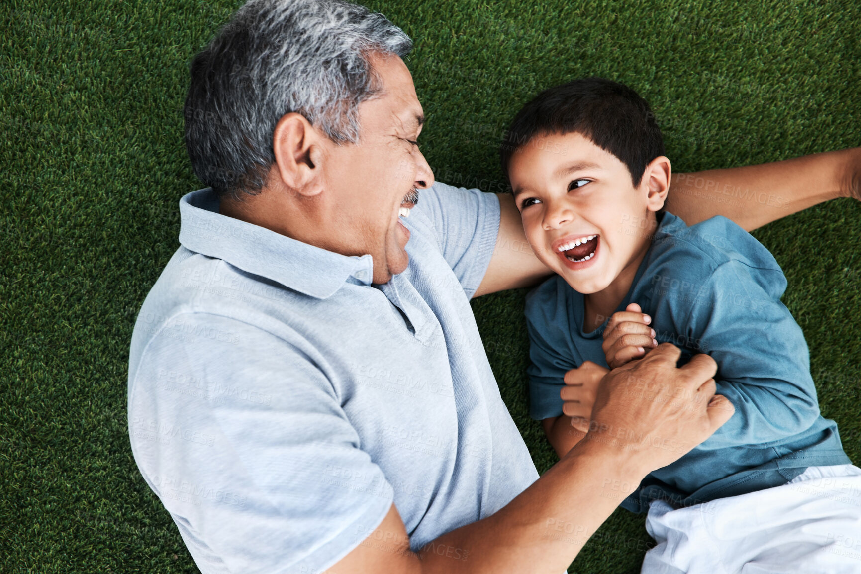 Buy stock photo Grandfather, child and laughing on grass having fun with love and grandparent care. Laugh, happy kid from above and senior man together outdoor on summer vacation with family and bonding in nature