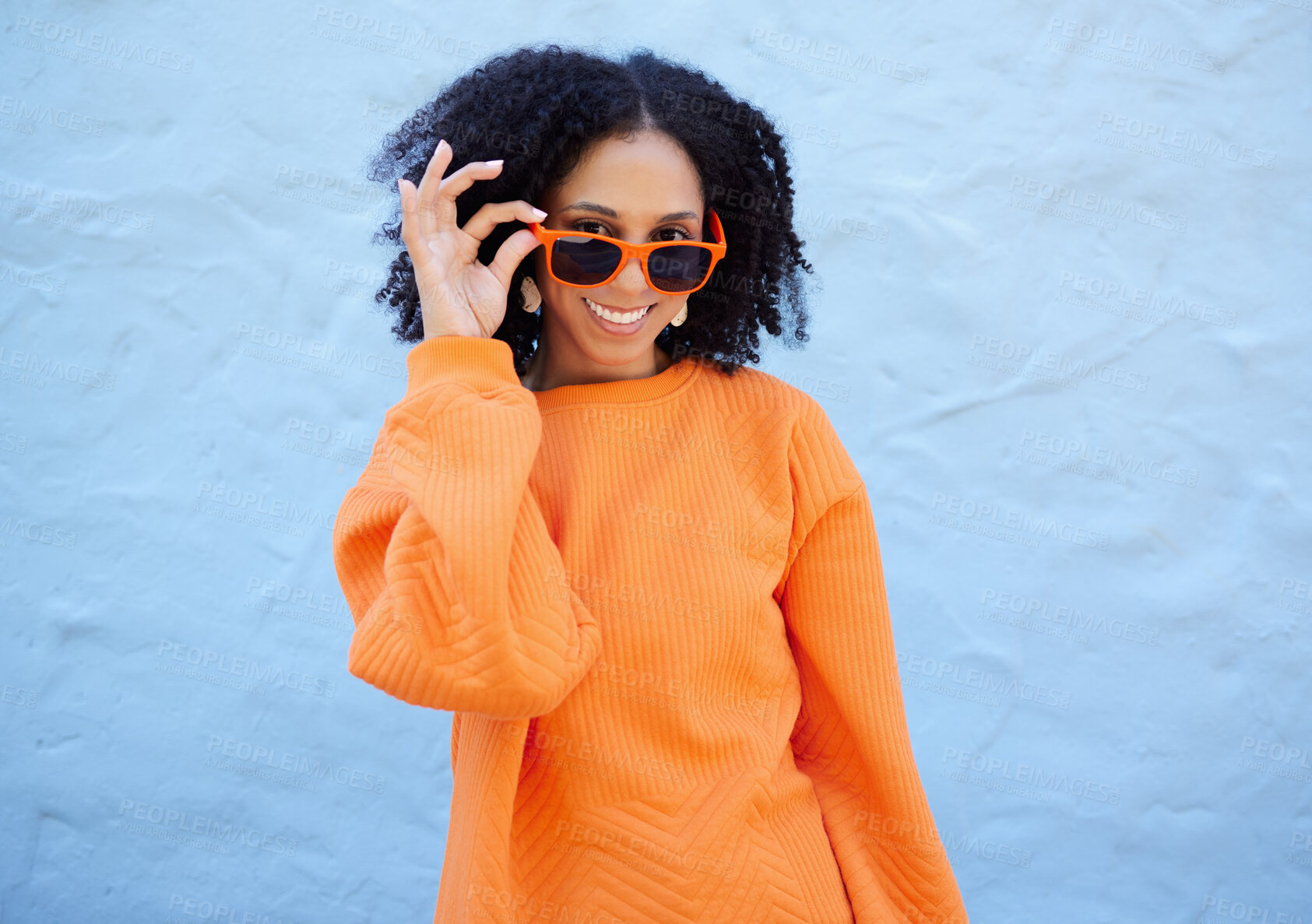 Buy stock photo Trendy, portrait and woman with sunglasses by a wall in the city on a vacation or weekend trip. Happy, smile and female with orange, fashion or stylish eyewear in town while on a holiday in Mexico.