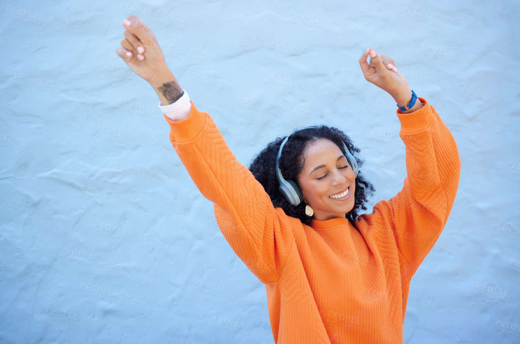 Buy stock photo Black woman, hands up or dancing to headphones music on isolated blue background, fashion mockup or wall mock up. Smile, happy or dancer student listening to radio, audio or energy podcast in freedom