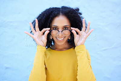 Buy stock photo Spectacle glasses, portrait and black woman on blue background, optical face and trendy cool clothes. Eyewear, smile and happy girl model with vision lenses, yellow color fashion or urban wall mockup