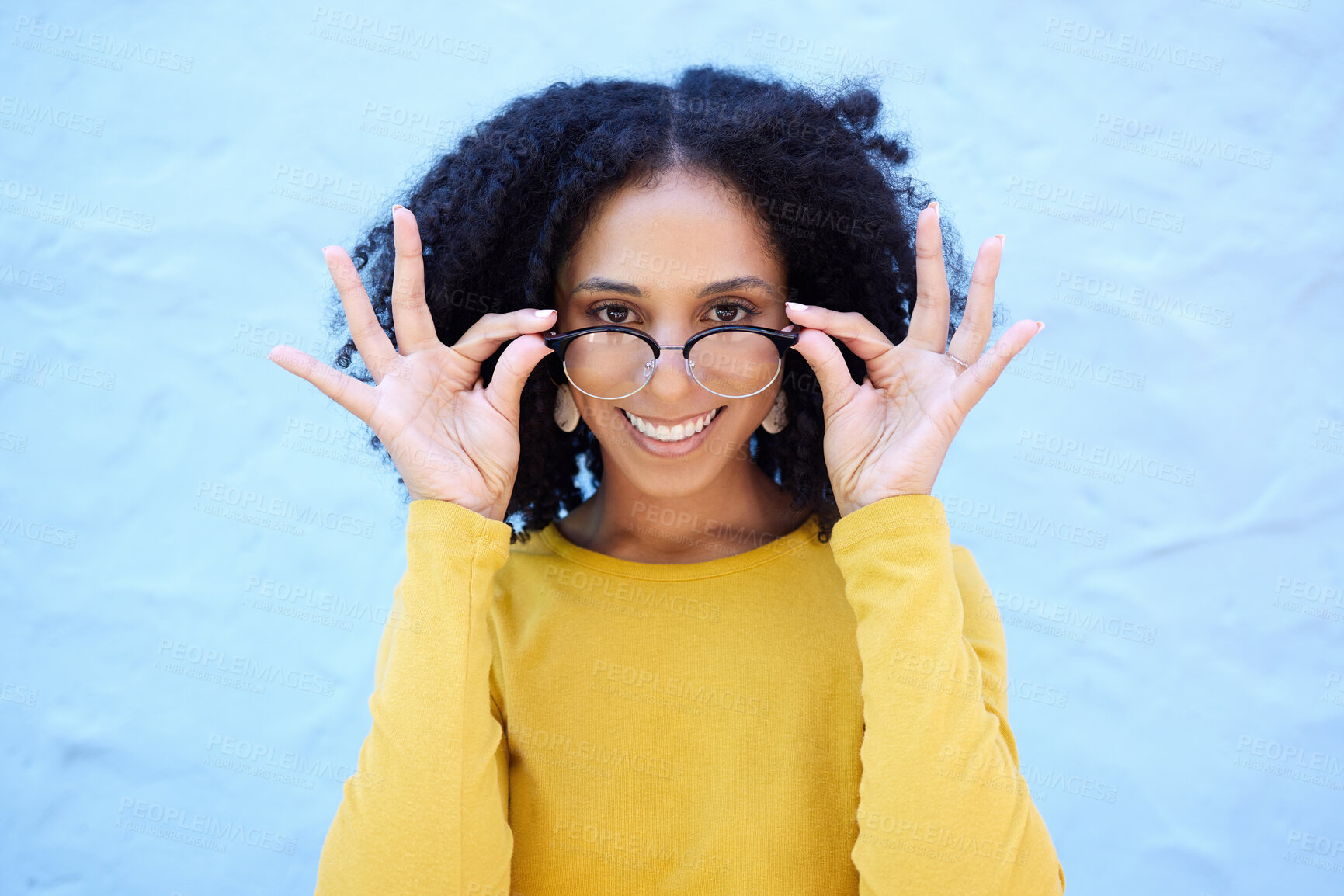 Buy stock photo Spectacle glasses, portrait and black woman on blue background, optical face and trendy cool clothes. Eyewear, smile and happy girl model with vision lenses, yellow color fashion or urban wall mockup