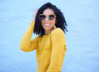 Buy stock photo Fashion sunglasses, portrait and black woman on blue background, excited face and trendy cool clothes. Summer, shades and happy girl model smile with vision, yellow color style and urban wall mockup