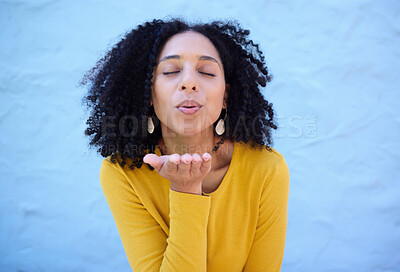 Buy stock photo Black woman blowing kiss in air for love, care and flirting on blue background, wall backdrop or outdoor. Young girl, hand kisses and expression of happiness, romance and kissing face emoji with lips