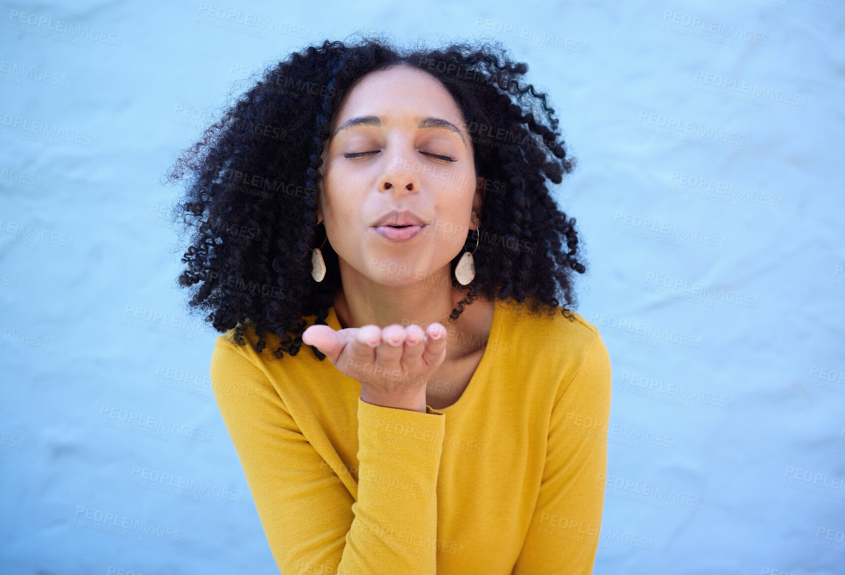 Buy stock photo Black woman blowing kiss in air for love, care and flirting on blue background, wall backdrop or outdoor. Young girl, hand kisses and expression of happiness, romance and kissing face emoji with lips