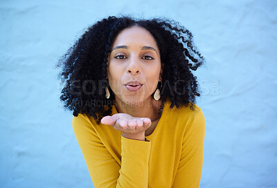 Buy stock photo Black woman, portrait and blowing kiss for love, care and flirting on blue background, wall backdrop or outdoor. Young girl, hand kisses and expression of happiness, romance and kissing face emoji 