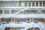 Library, interior design and university for education, learning and knowledge building background. Campus, bookshelf, architecture and empty room or stairs space for learning, scholarship or research