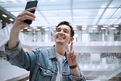 Buy stock photo Selfie, university and man student with peace sign for social media update, blog post or live streaming his experience. Education, research and person in campus library with smile for profile picture