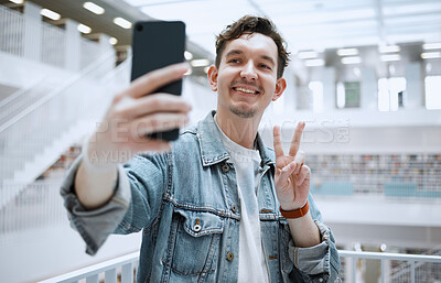 Buy stock photo Library, selfie and university man with peace sign for lifestyle update, social media or blog post with happy education. Research, study and phd student or person with emoji sign for profile picture