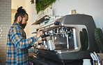 Cafe, startup and service with a man barista behind the counter to prepare a drink. Coffee shop, kitchen and waiter with a male working in a restaurant as an entrepreneur or small business owner