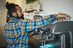 Man in cafe, barista and machine for drink with focus and small business, workflow and process. Clean up are espresso, latte or cappuccino production, coffee shop with hygiene and disinfection